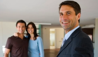 A realtor from Larry Weltman Consulting and a happy couple stand together in a bright apartment
